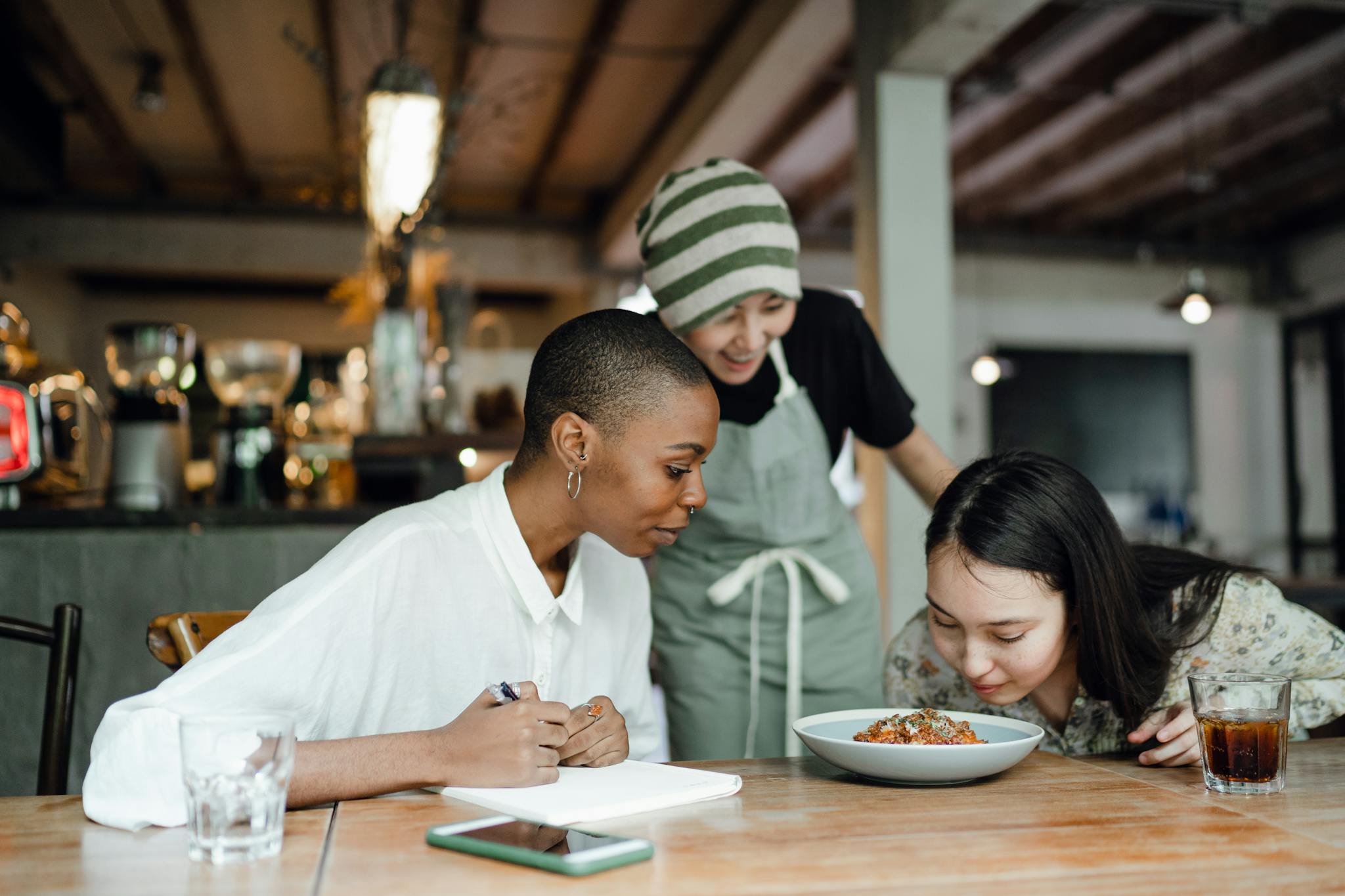 cheerful coworkers tasting and smelling food in